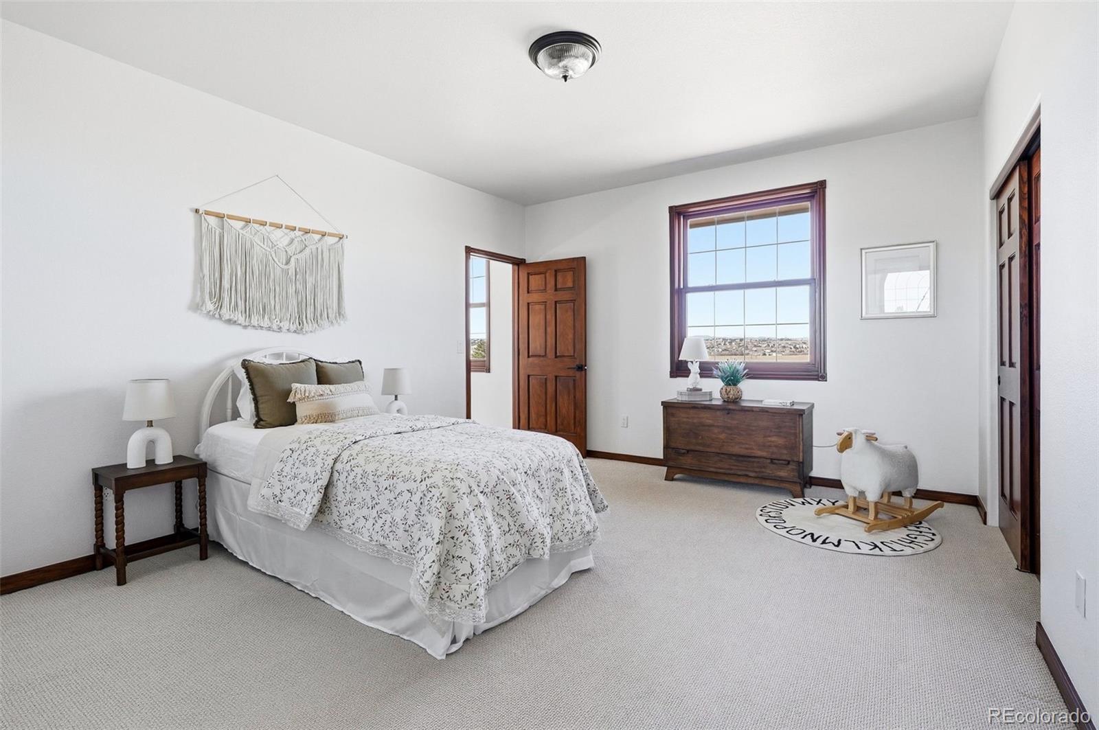 4347 Crowfoot Valley Road Castle Rock, CO 80108 - Photo 24 of 50 a spacious bedroom with a bed and a couch