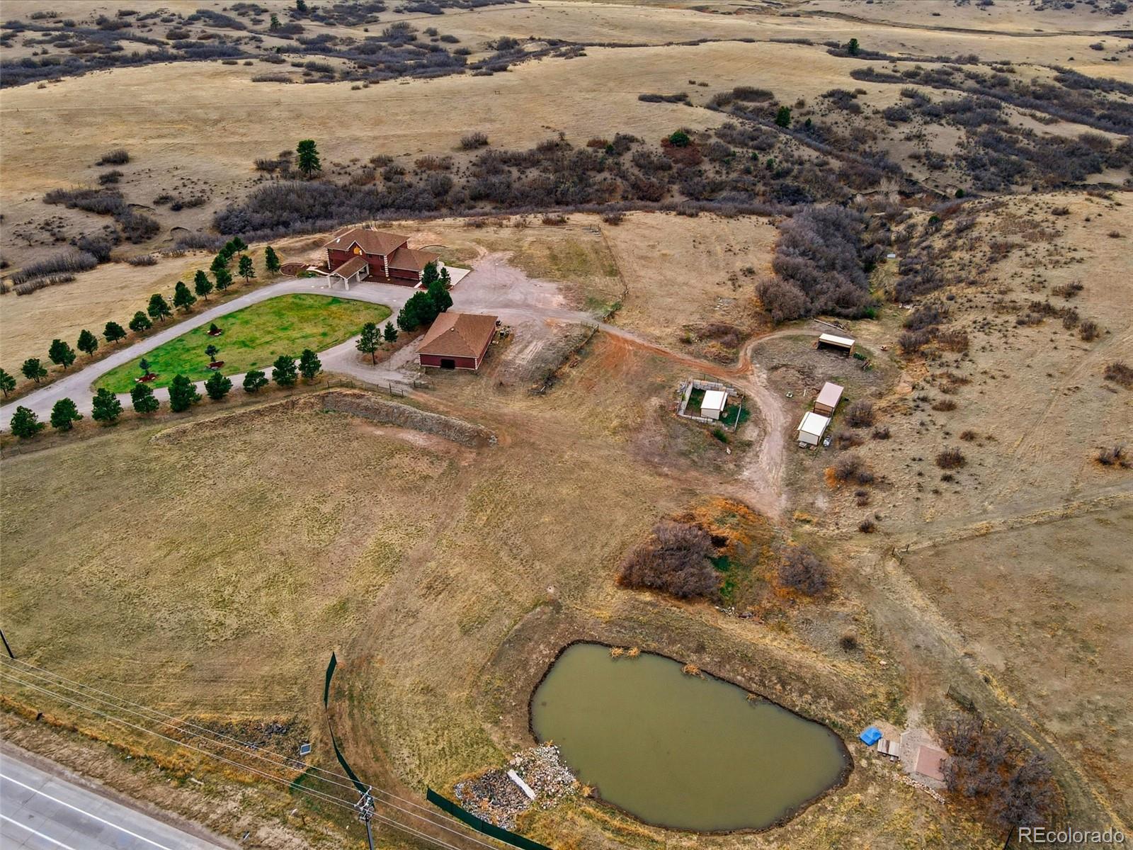 4347 Crowfoot Valley Road Castle Rock, CO 80108 - Photo 42 of 50 an aerial view of a house with a yard and lake view