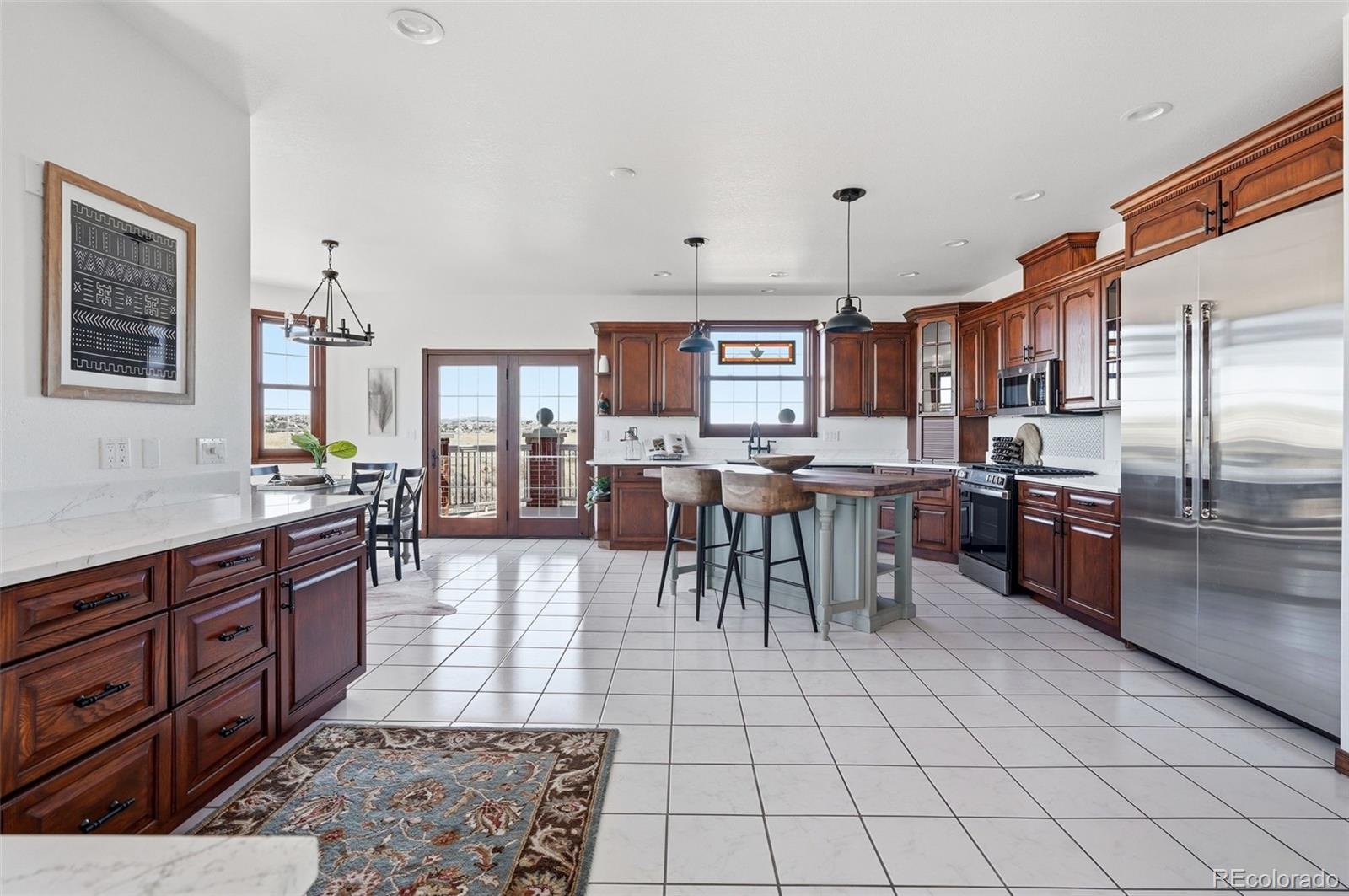 4347 Crowfoot Valley Road Castle Rock, CO 80108 - Photo 9 of 50 a kitchen with stainless steel appliances granite countertop a stove top oven a sink a dining table and chairs