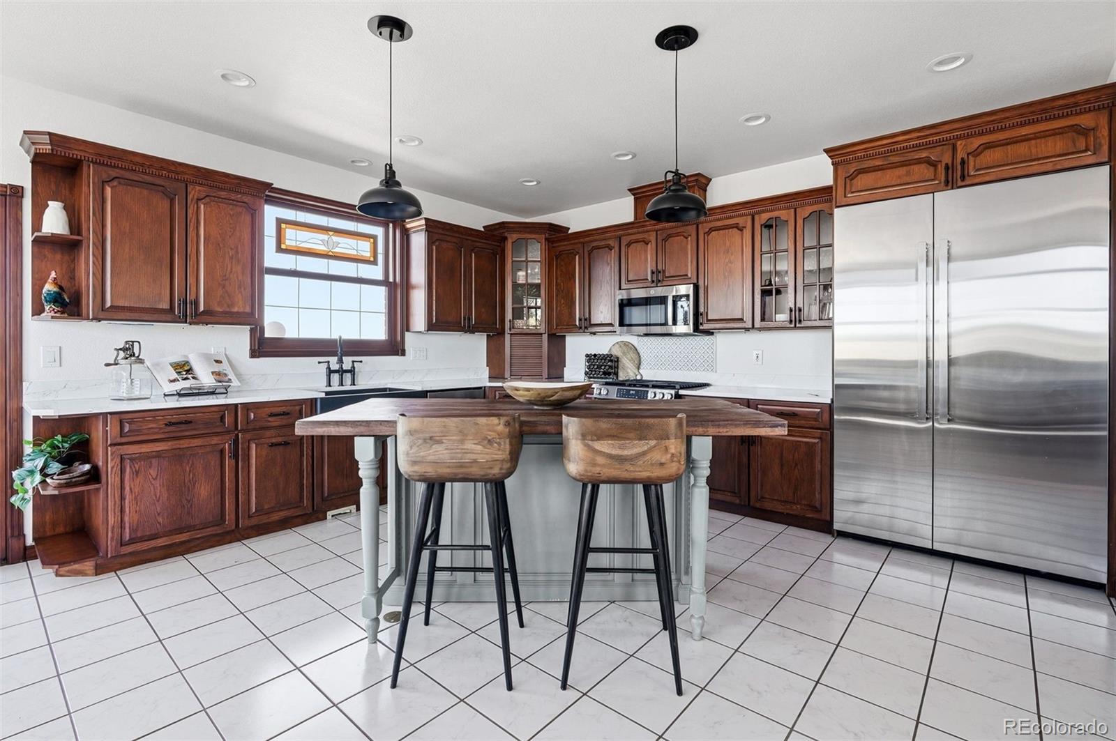 4347 Crowfoot Valley Road Castle Rock, CO 80108 - Photo 10 of 50 a kitchen with granite countertop a sink appliances a counter space and a center island