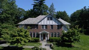 a front view of a house with yard and green space