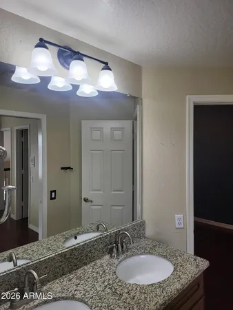 an empty room with wooden floor chandelier fan and windows