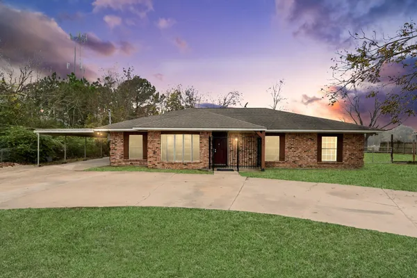 a front view of a house with a garden and yard
