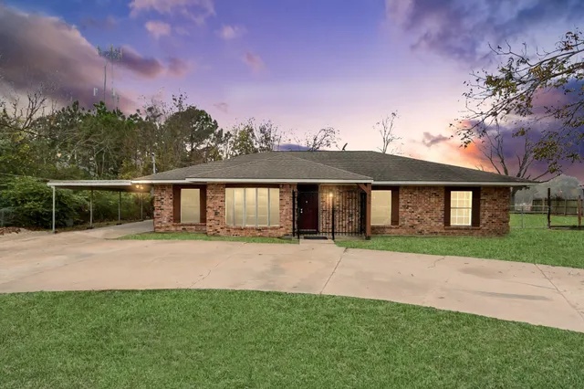 a front view of a house with a garden and yard