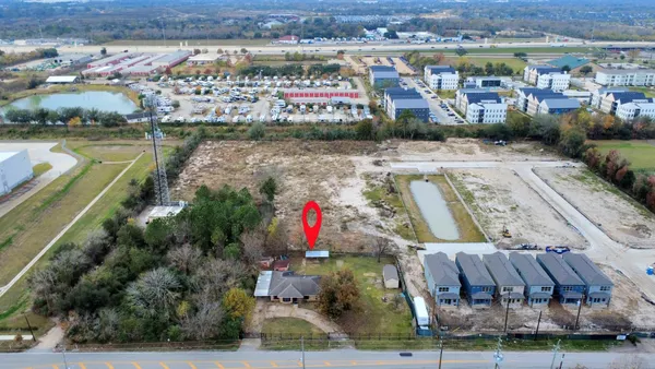 an aerial view of residential houses with outdoor space and swimming pool