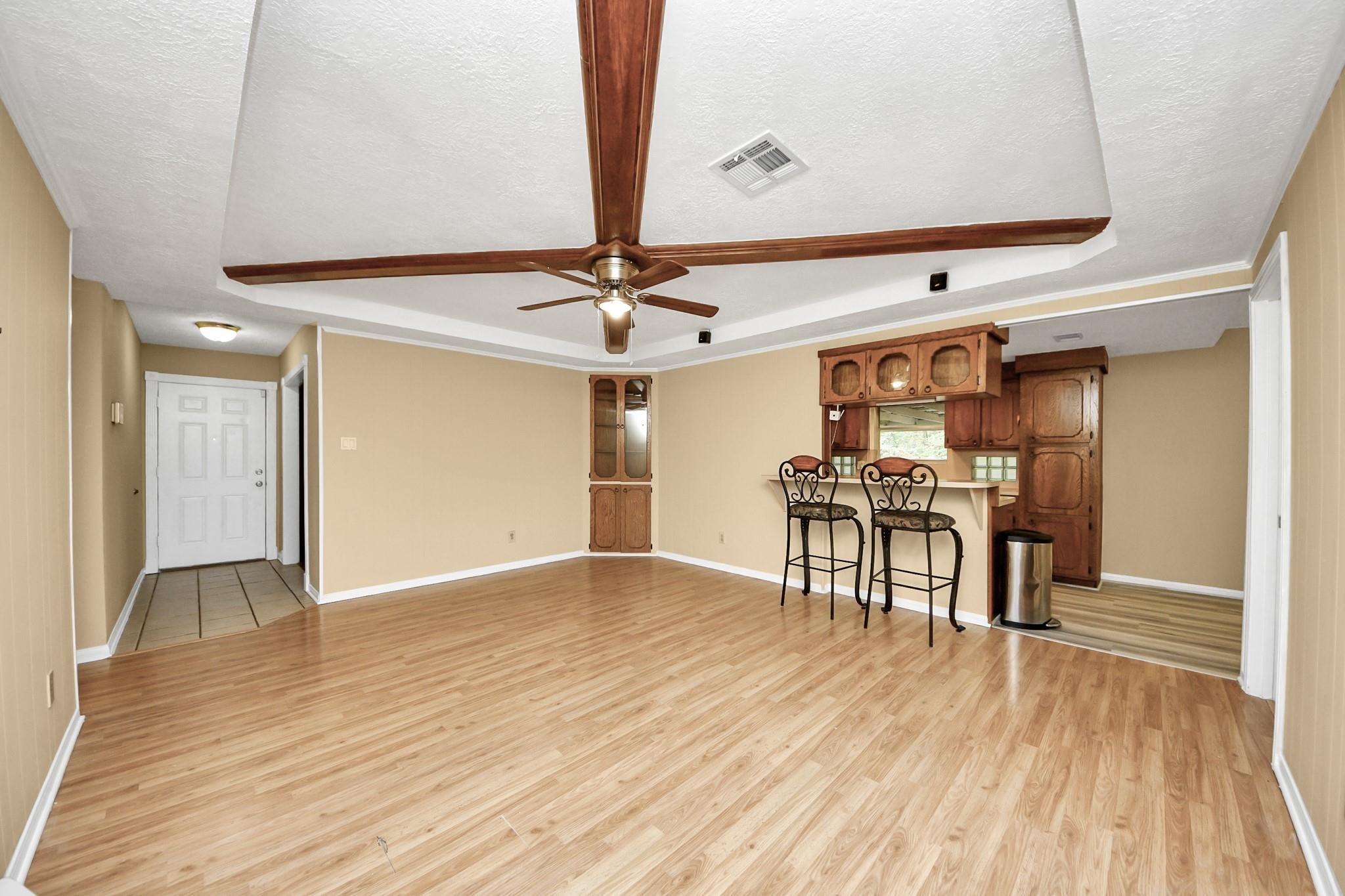 13610 Furman Road Houston, TX 77047 - Photo 6 of 25 a view of a room with wooden floor a ceiling fan and kitchen space