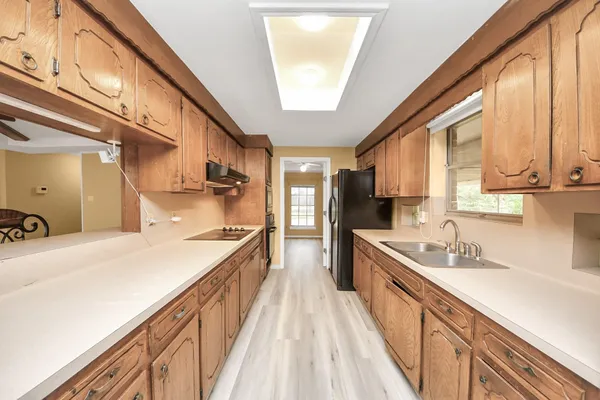 a large kitchen with stainless steel appliances granite countertop a lot of counter space and wooden floors