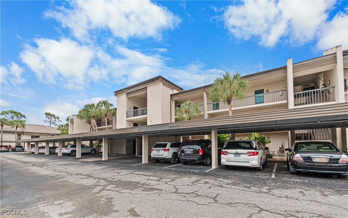 5905 Trailwinds Drive, Unit 824 Fort Myers, FL 33907 - Photo 2 of 50 a view of a cars park in front of a building
