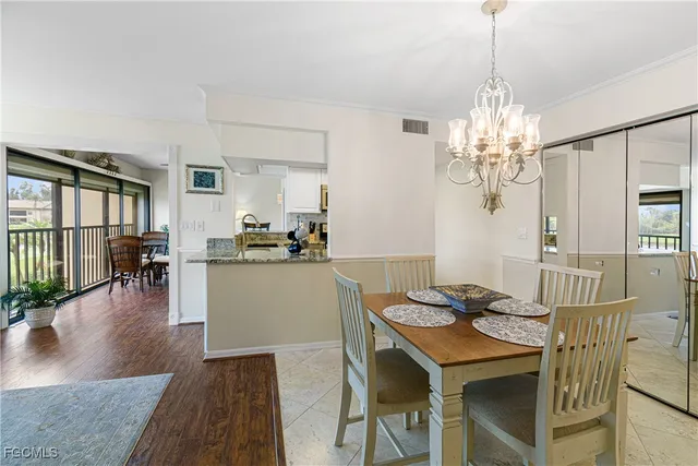 a dining room with furniture a chandelier and wooden floor