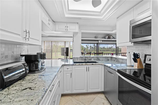 a kitchen with stainless steel appliances granite countertop a sink and stove top oven