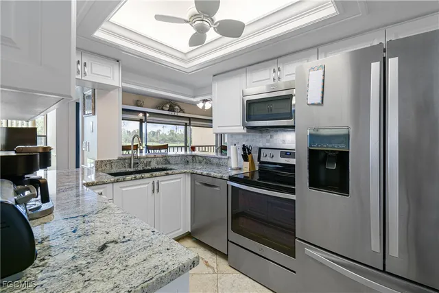 a kitchen with stainless steel appliances granite countertop a refrigerator a stove top oven a sink and dishwasher