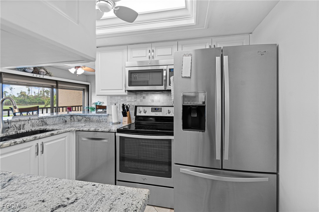 5905 Trailwinds Drive, Unit 824 Fort Myers, FL 33907 - Photo 34 of 50 a kitchen with stainless steel appliances a refrigerator sink and microwave