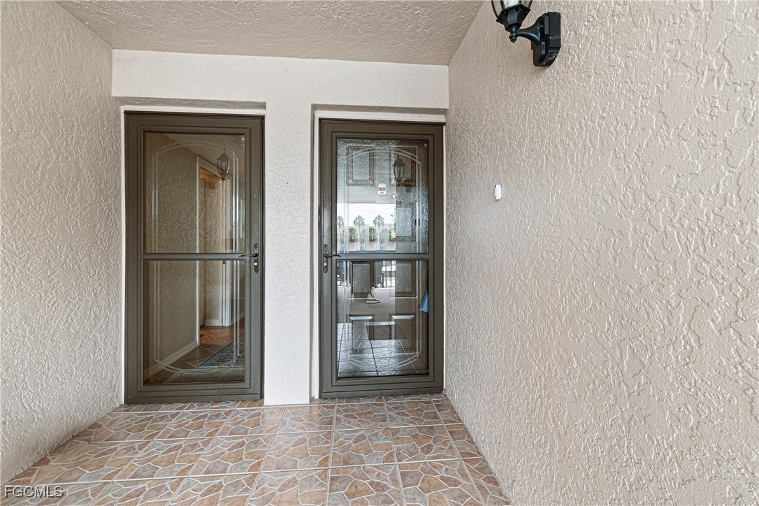 5905 Trailwinds Drive, Unit 824 Fort Myers, FL 33907 - Photo 4 of 50 a view of a hallway with a glass door and a window