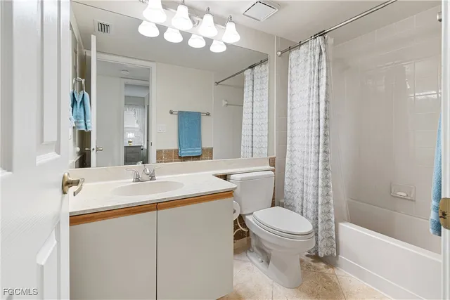a bathroom with a sink a toilet a mirror a bathtub and shower