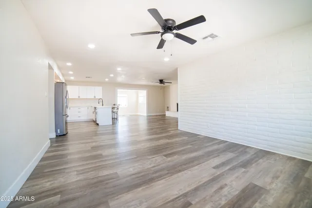 a view of a livingroom with a hardwood floor and a ceiling fan