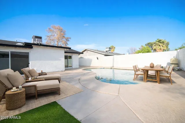 a view of a patio with couches and table and chairs and potted plants