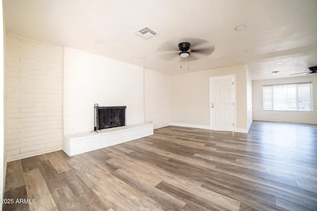 a view of an empty room with a fireplace and a window