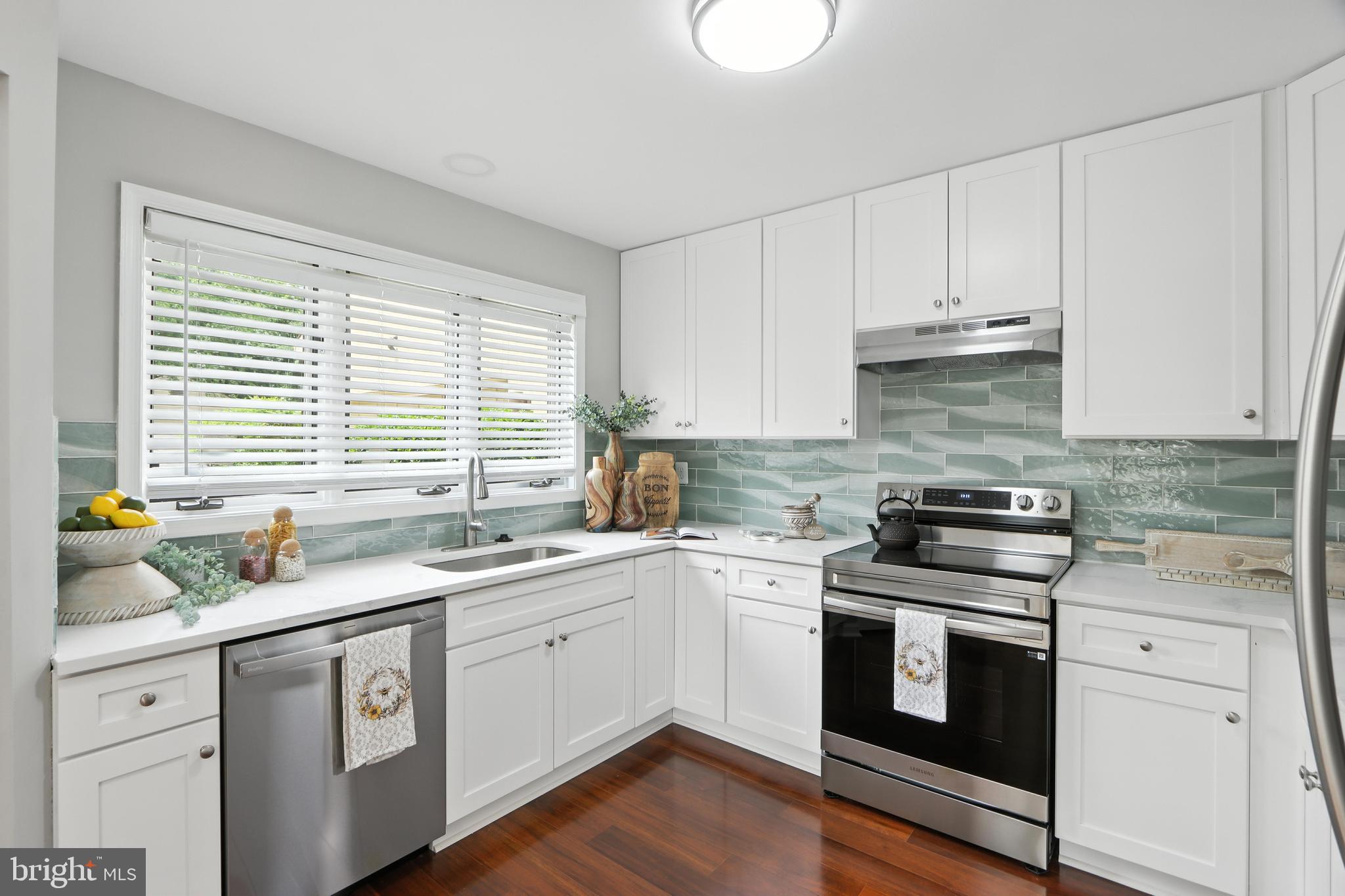 3005 Courtside Road Bowie, MD 20721 - Photo 17 of 43 a kitchen with white cabinets appliances a sink and a window