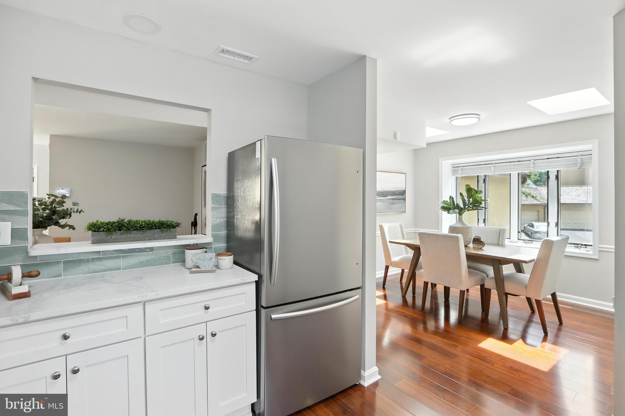 3005 Courtside Road Bowie, MD 20721 - Photo 19 of 43 a kitchen with stainless steel appliances a dining table chairs refrigerator and cabinets
