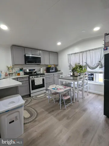 a kitchen with a table chairs microwave and cabinets
