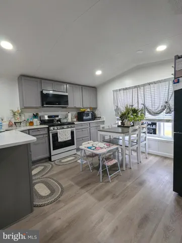 a kitchen with a table chairs microwave and cabinets