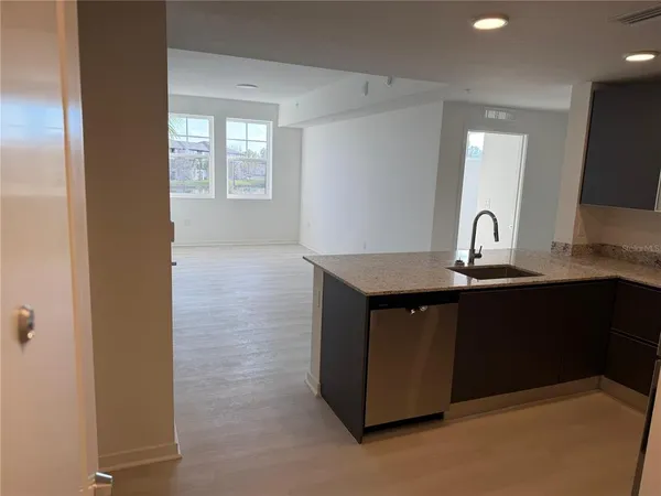 a kitchen with granite countertop a sink and cabinets