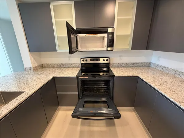 a kitchen with granite countertop a stove and a microwave