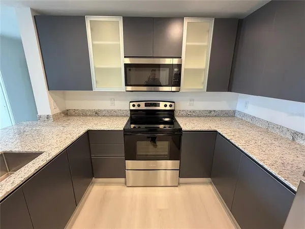 a kitchen with granite countertop a stove and a sink