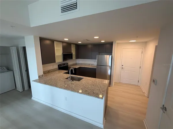 a kitchen with stainless steel appliances granite countertop a refrigerator and a sink