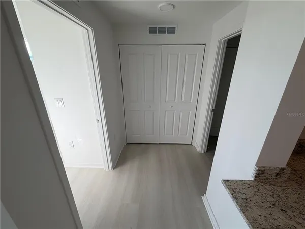 a view of a hallway with wooden floor and staircase