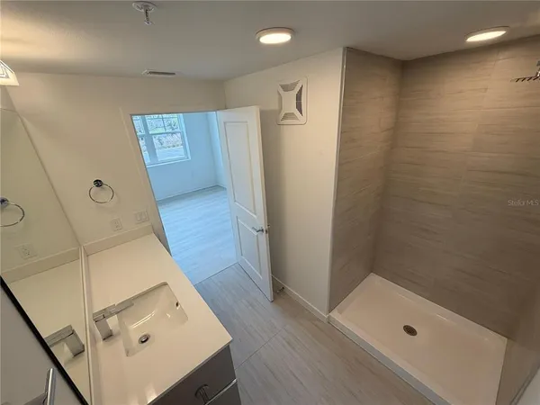 a bathroom with a tub shower vanity and a sink