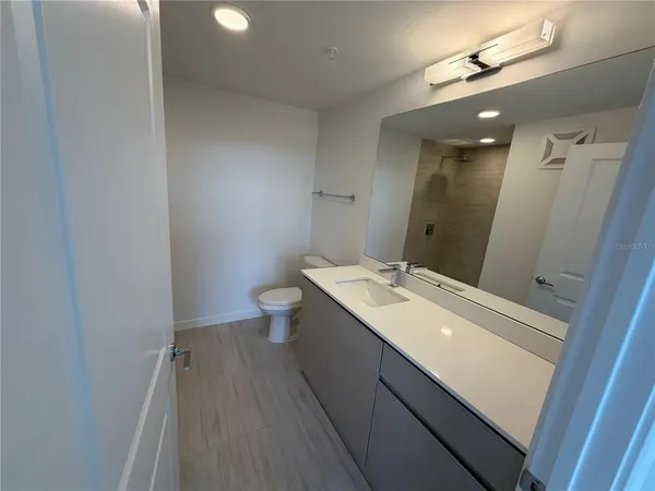 a bathroom with a sink a toilet and a mirror