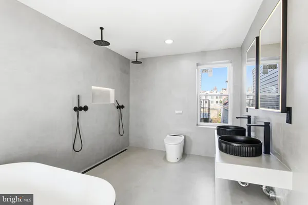 a bathroom with a granite countertop toilet sink and mirror