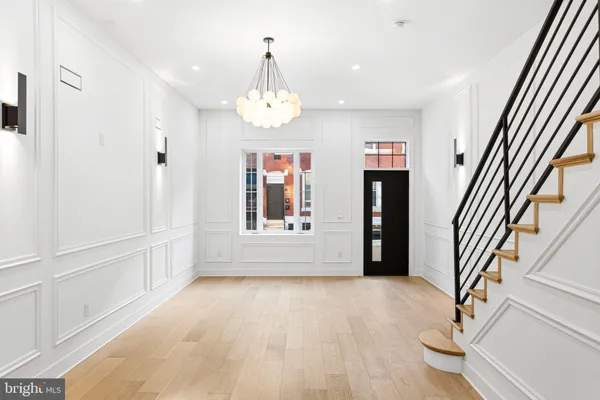 en view of an empty room with wooden floor and a window