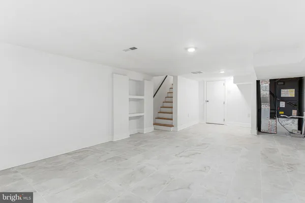 an empty room with a white wall and closet