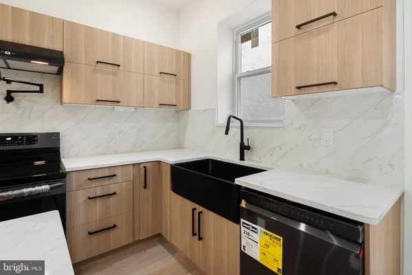 a kitchen with granite countertop white cabinets and black appliances