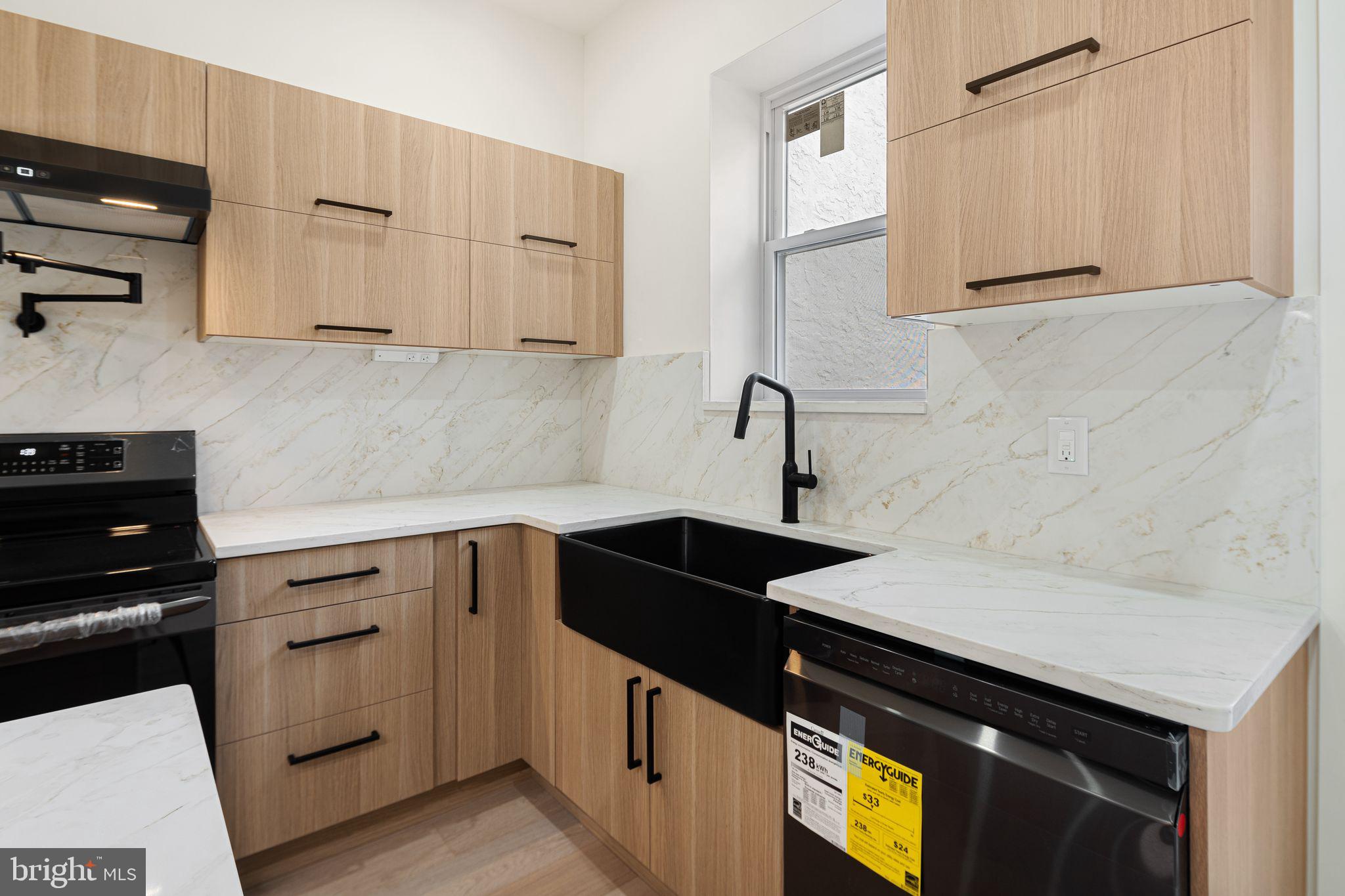1419 Wharton Street Philadelphia, PA 19146 - Photo 7 of 39 a kitchen with granite countertop white cabinets and black appliances