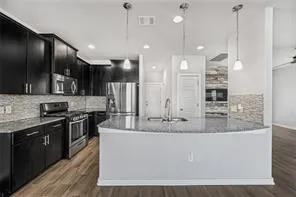 a large kitchen with kitchen island a large counter top space a sink and stainless steel appliances
