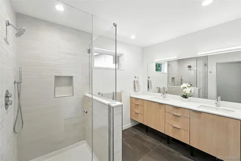 a bathroom with a double vanity sink mirror and shower