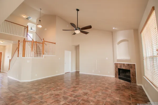 a view of an empty room with a fireplace and a window
