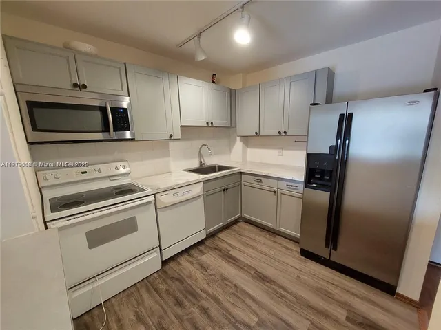 a kitchen with cabinets stainless steel appliances and a counter space