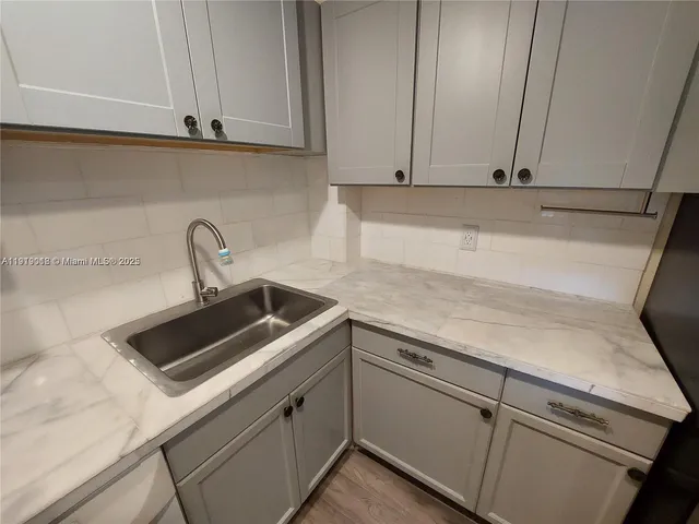 a kitchen with stainless steel appliances granite countertop a sink and a white cabinets