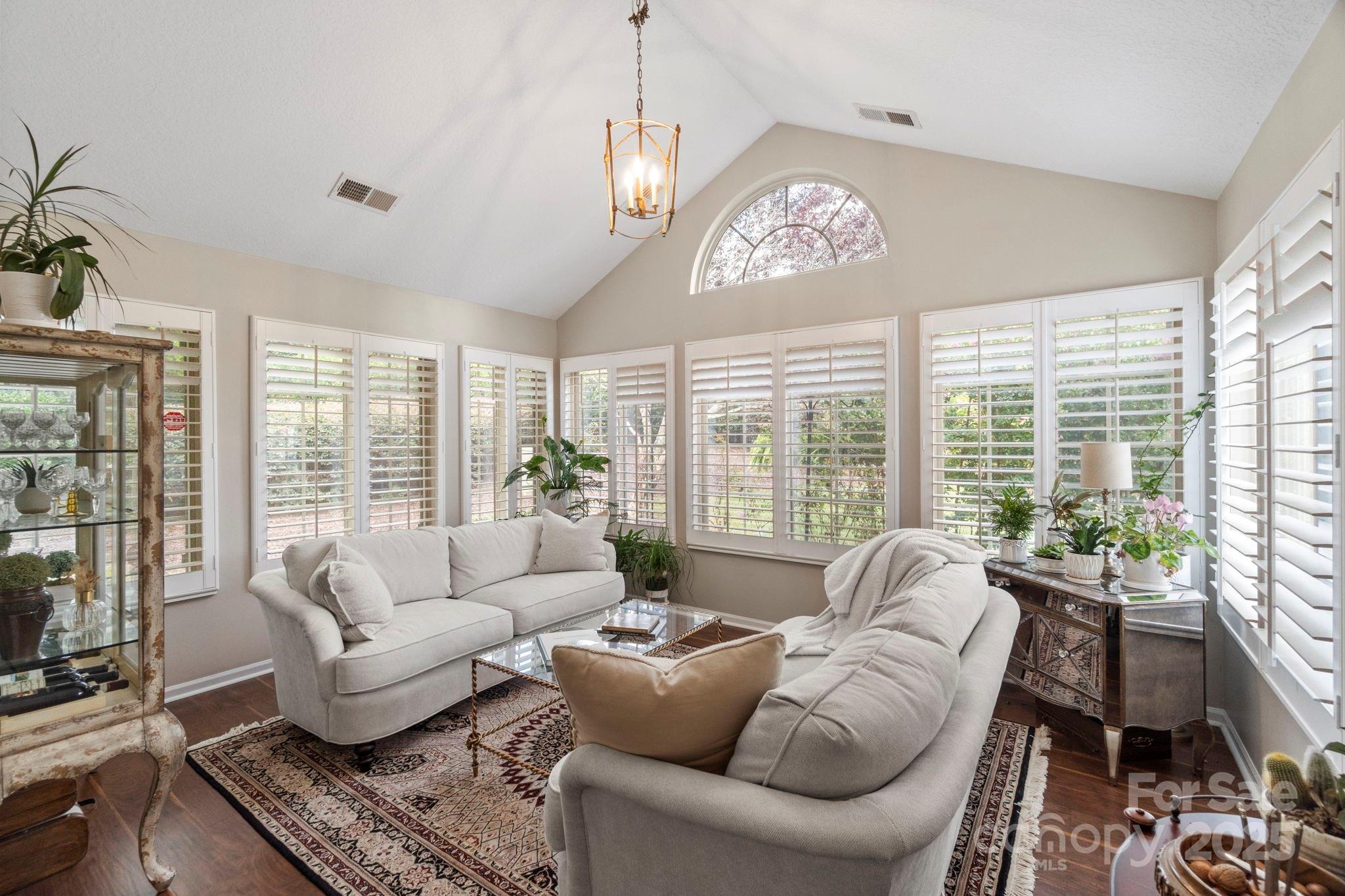2459 Coltsview Lane Matthews, NC 28105 - Photo 7 of 31 a living room with furniture floor to ceiling windows and a chandelier