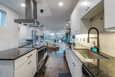 a kitchen with stainless steel appliances a sink stove and cabinets