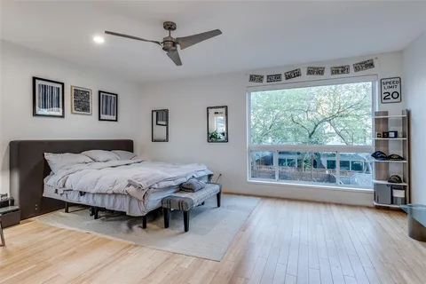 a spacious bedroom with a large bed and a wooden floor