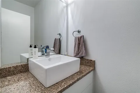 a bathroom with a granite countertop sink and a mirror