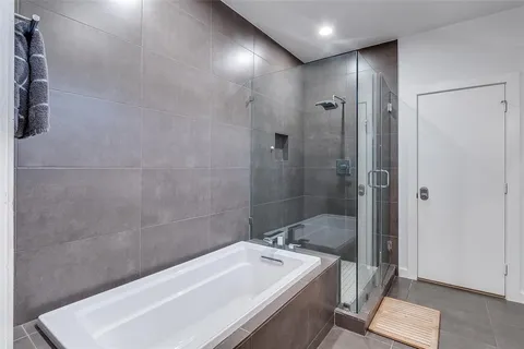 a bathroom with a tub a sink and shower