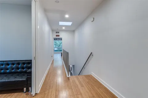 a view of a hallway with wooden floor and staircase