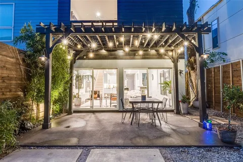a view of a patio with table and chairs potted plants and floor to ceiling window and potted plants