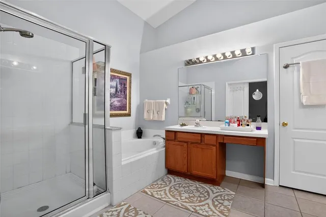 a spacious bathroom with a tub sink and mirror